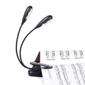 Clip-on music stand light with dual black gooseneck arms and clip base
