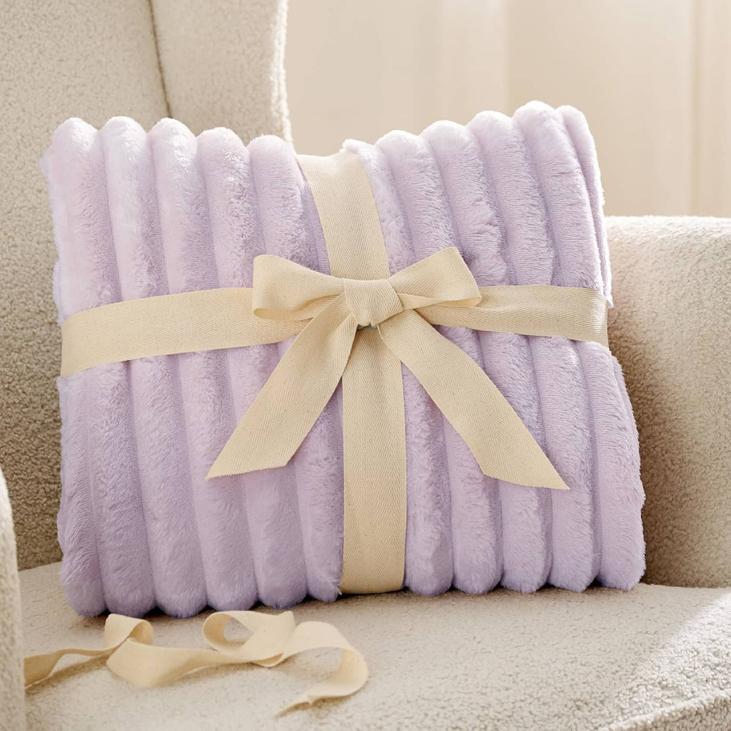 Lavender fog folded fleece blanket tied with a light ribbon bow