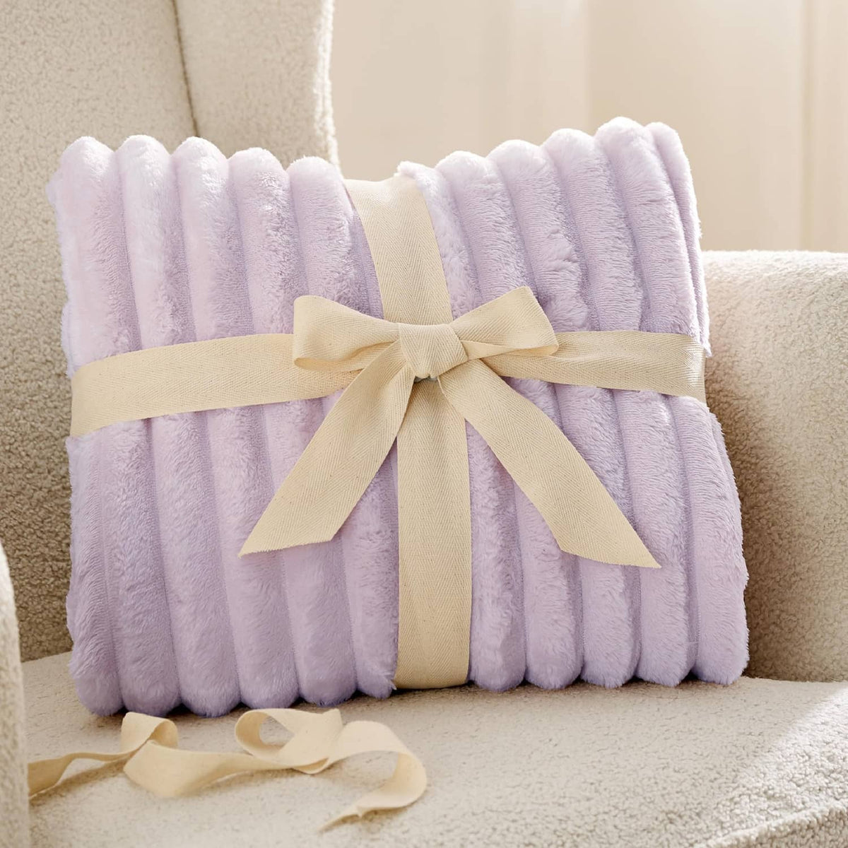 Lavender fog folded fleece blanket tied with a light ribbon bow