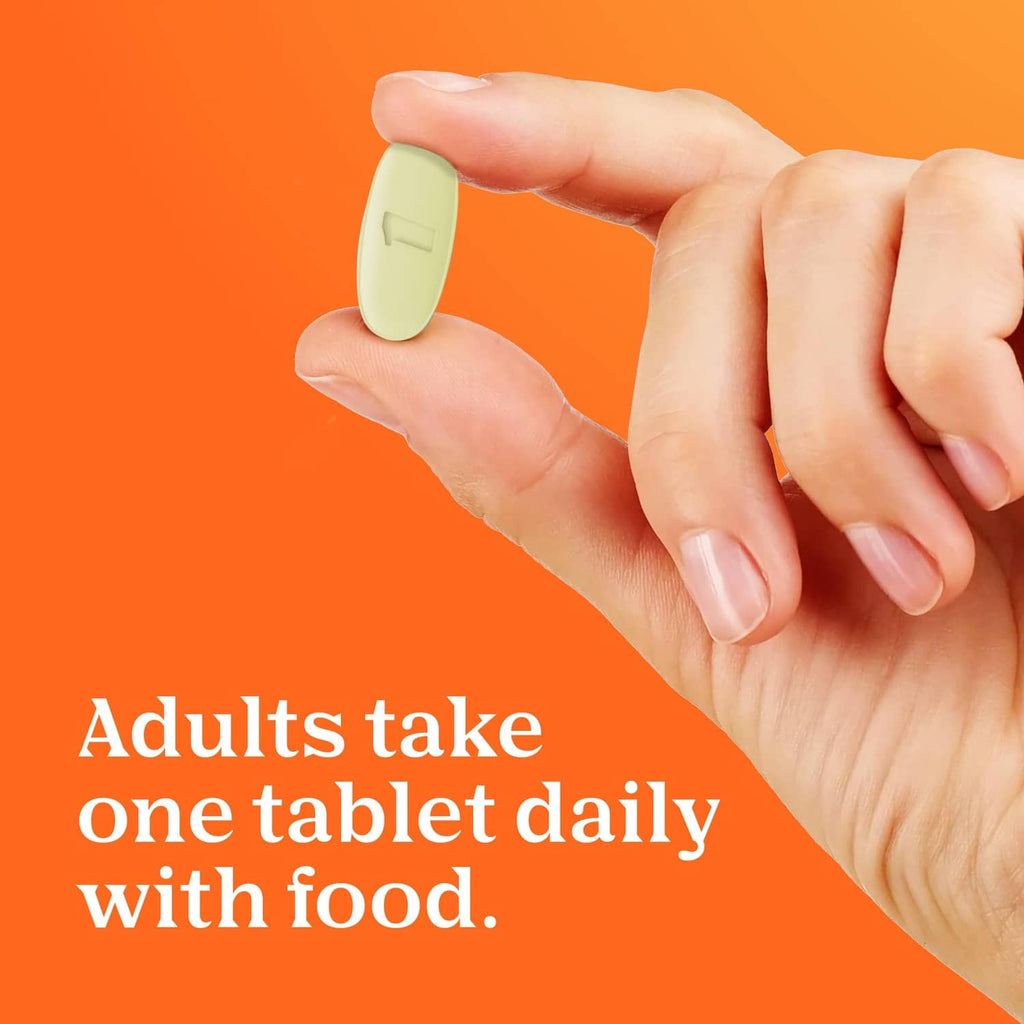 Hand holding a small white tablet, shown with women’s multivitamin usage message