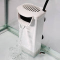 White aquarium filter pump with vented top, pouring water into tank via outlet hose