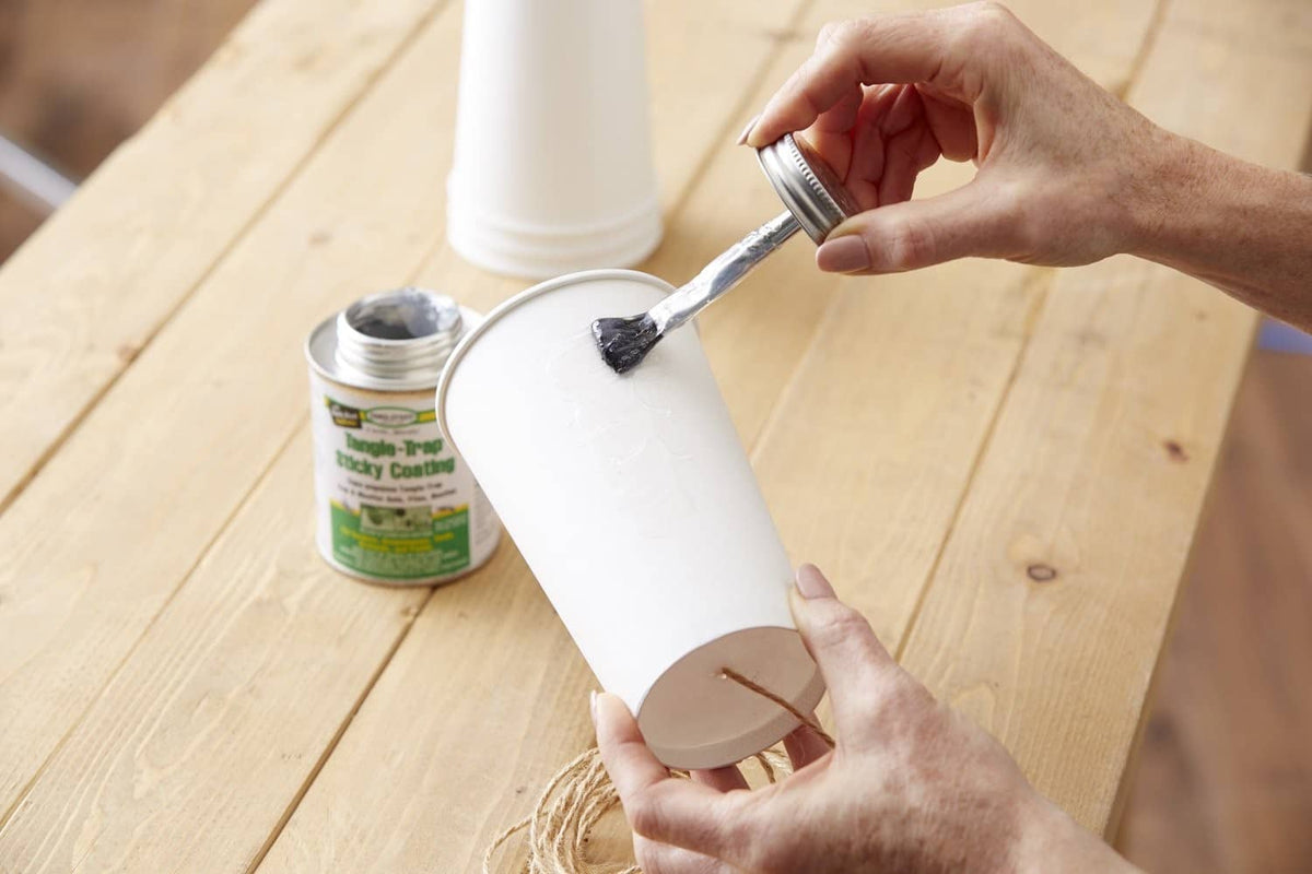Tangle-Trap sticky coating being brushed onto a white board with a metal brush.