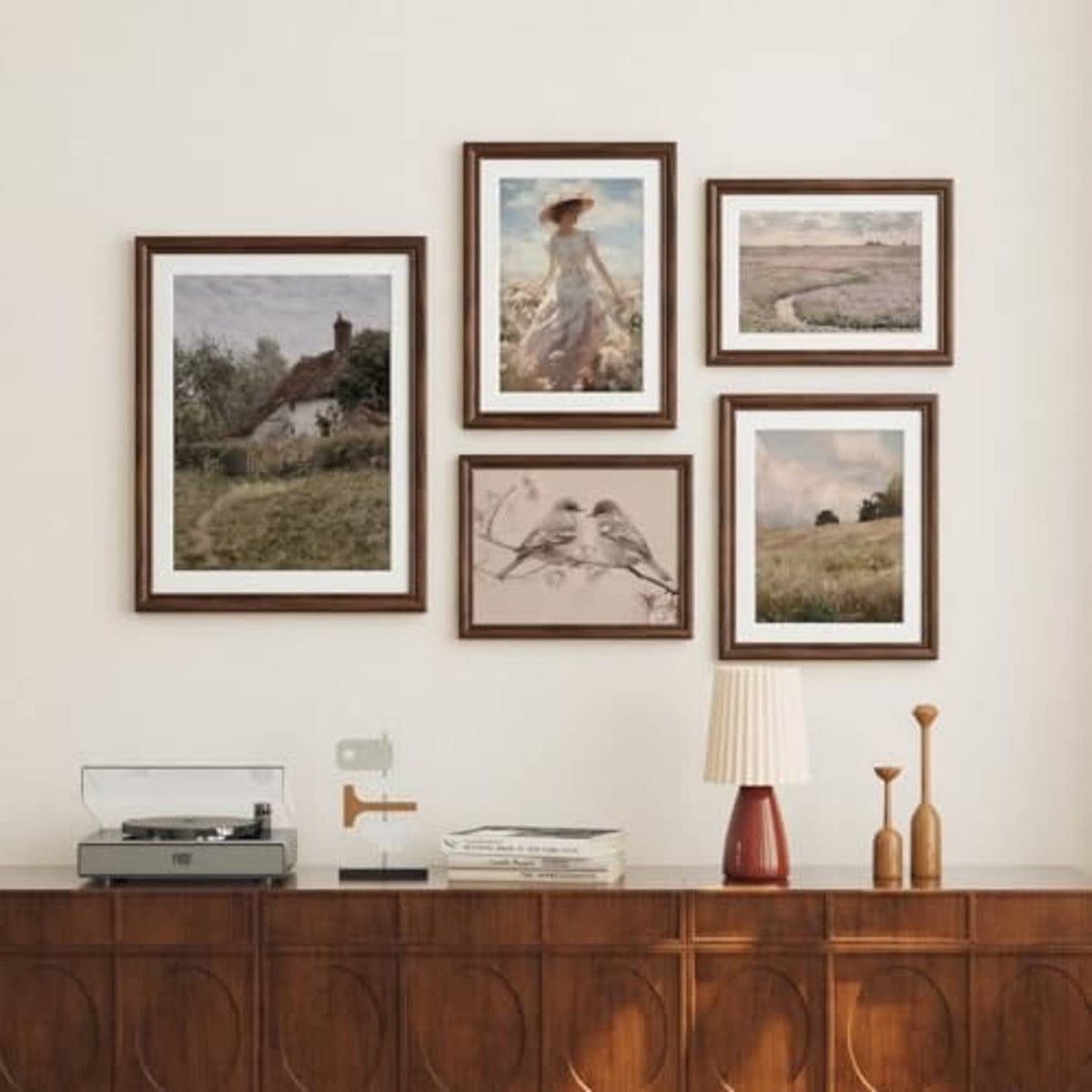 Group of walnut wood picture frames with small artwork, wall display arrangement