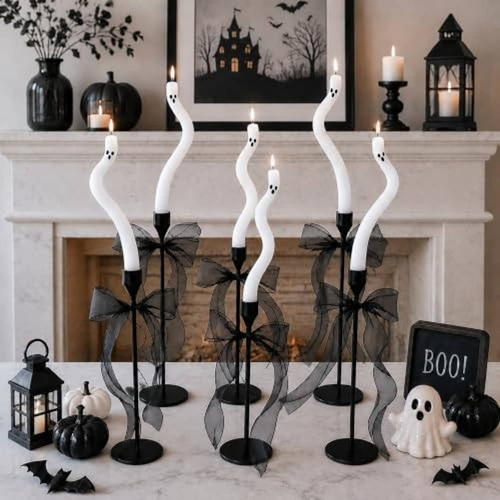 Five twisting white ghost candles with black bases and black tulle ribbon bows