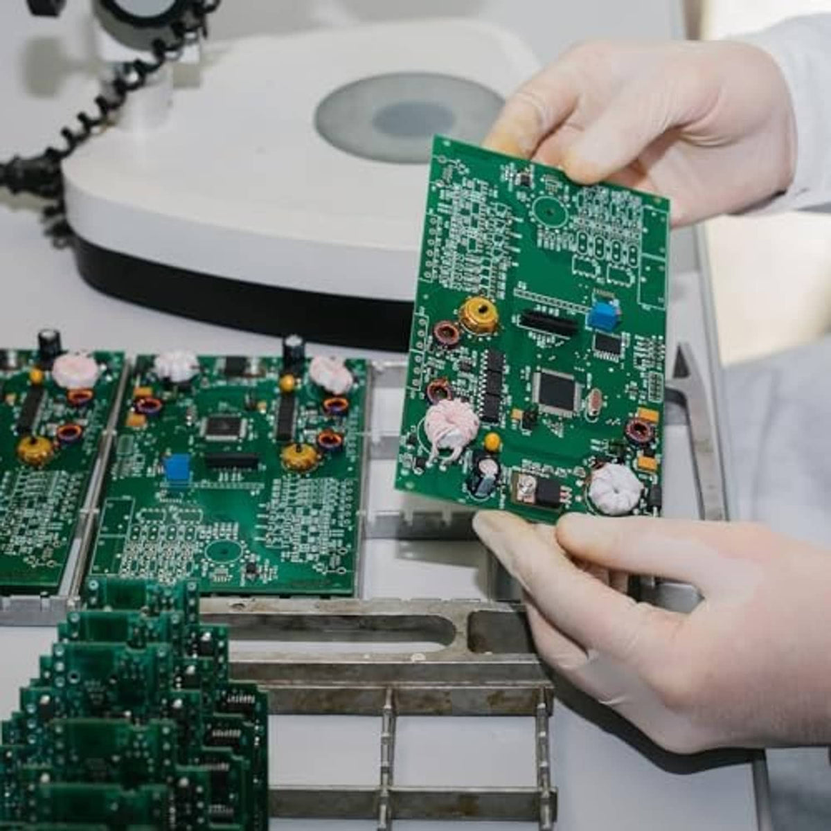 Multiturn trimmer potentiometer components on green circuit boards handled during electronics repair