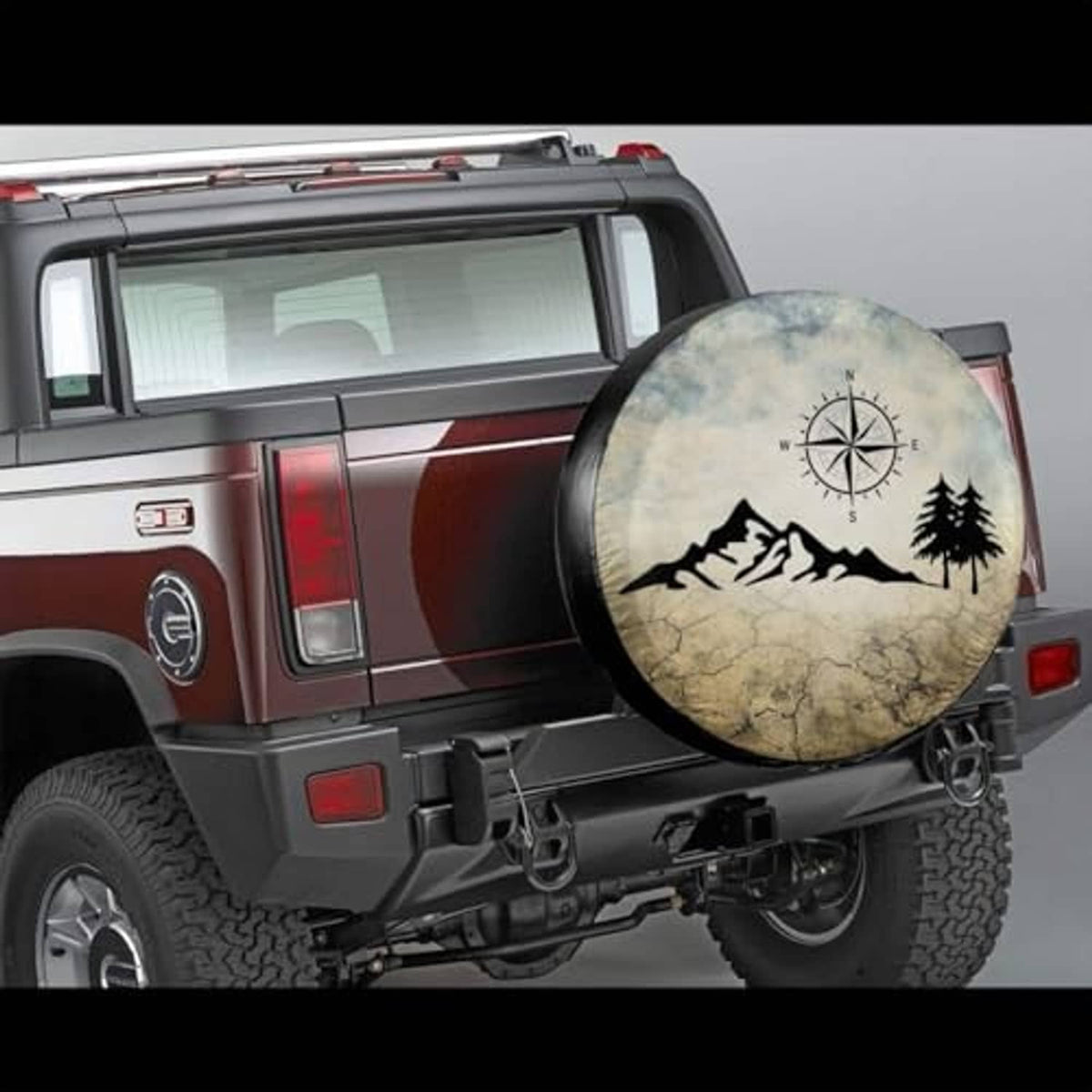 Round spare tire cover with compass-and-mountains design mounted on an off-road SUV