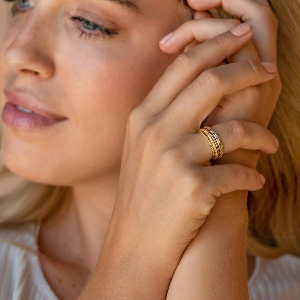 Gold-plated thin stackable rings with ridged and smooth bands on hand