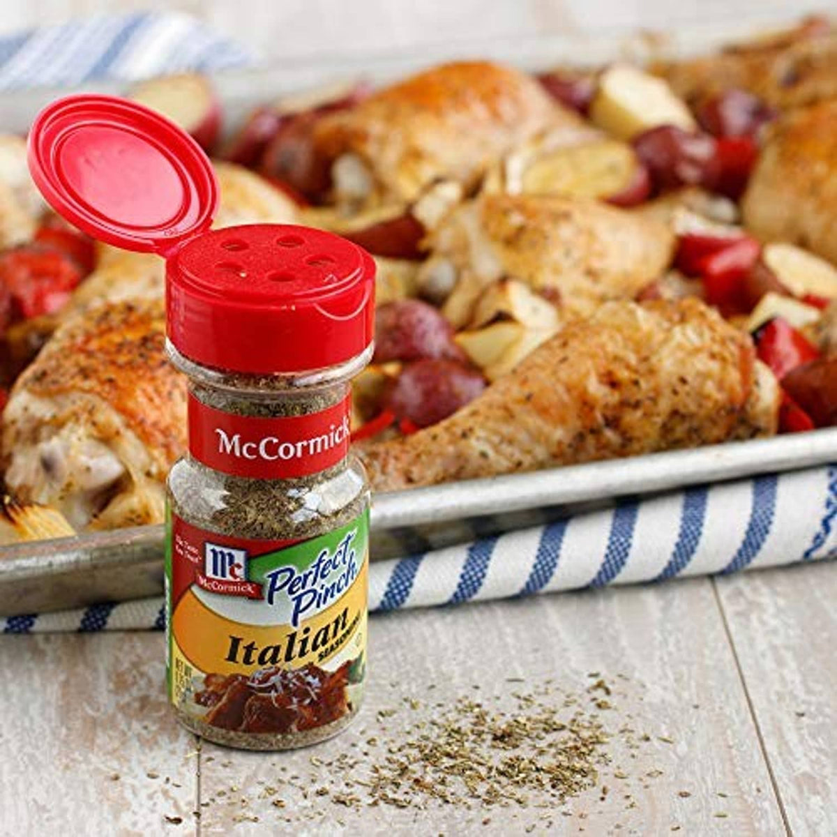 McCormick Perfect Pinch Italian seasoning bottle with red cap beside cooked food