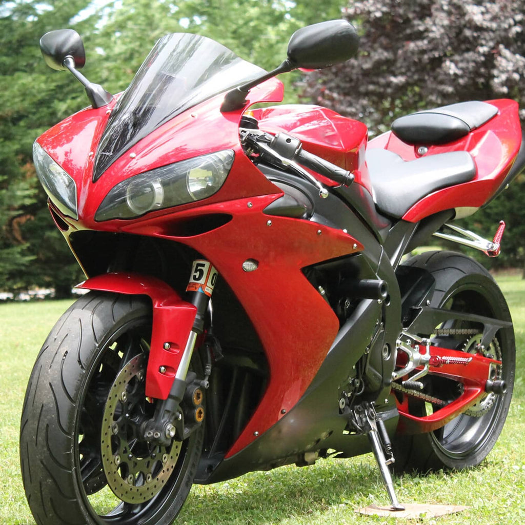 Black dual headlights and fairing bracket shown beneath a red sport motorcycle