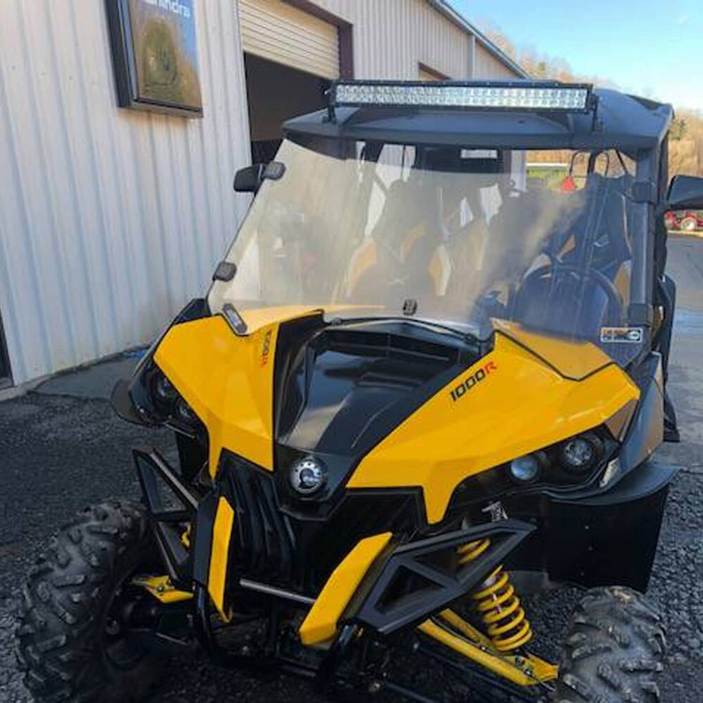 Clear full windshield mounted on yellow UTV with black roll cage and hardware