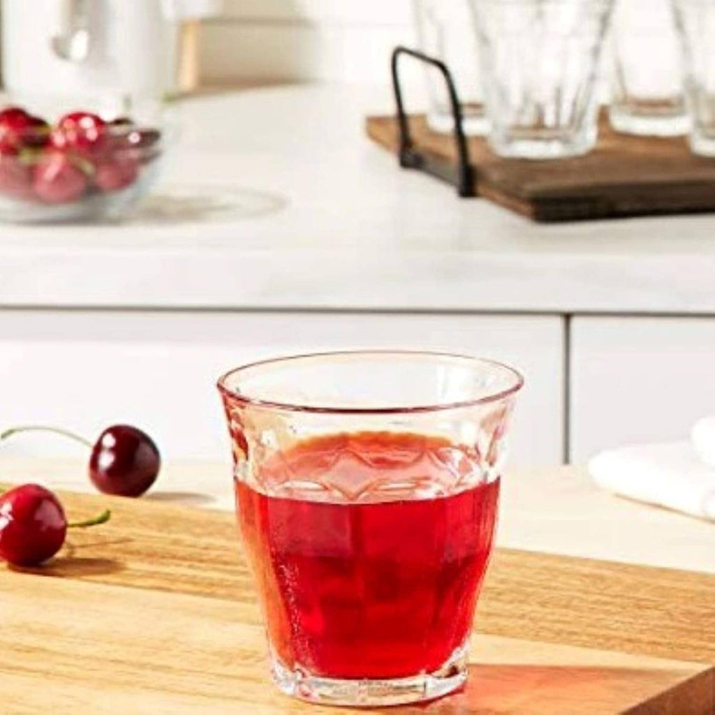 Clear glass tumbler filled with red iced drink