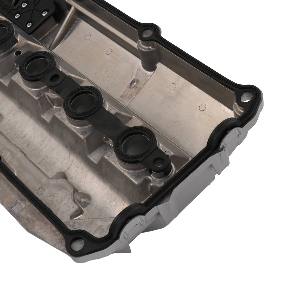 Valve cover gasket surface with multiple circular ports and black outer seal, close-up