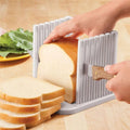 Plastic bread slicing guide with adjustable rails, holding loaf for even toast slices