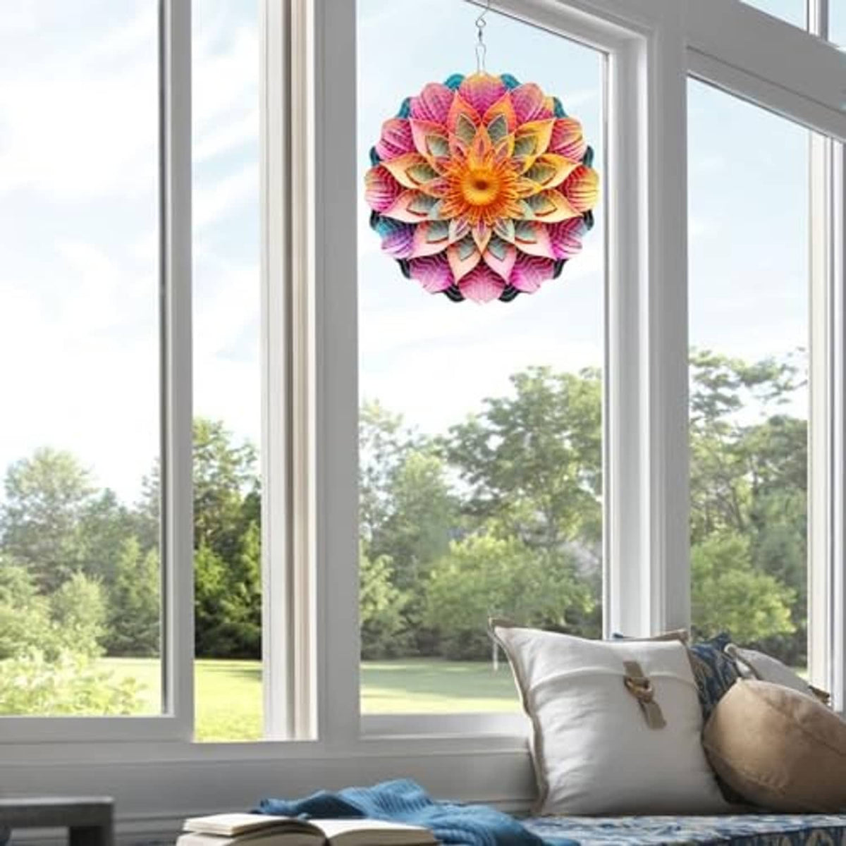 Colorful metal mandala wind spinner hanging in a window view