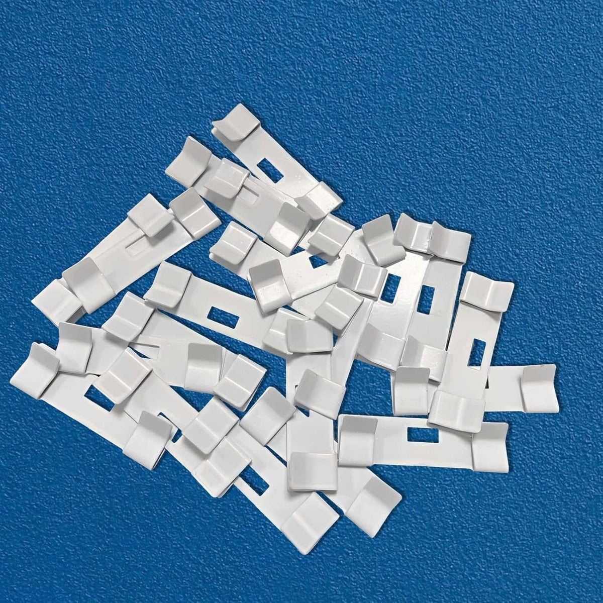 Pack of white metal vertical blind repair tabs, multiple small replacement clips