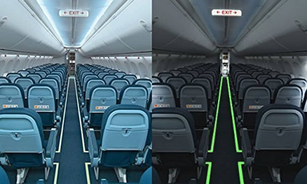 Glow-in-the-dark tape accents on airplane cabin handrails, forming bright green lines