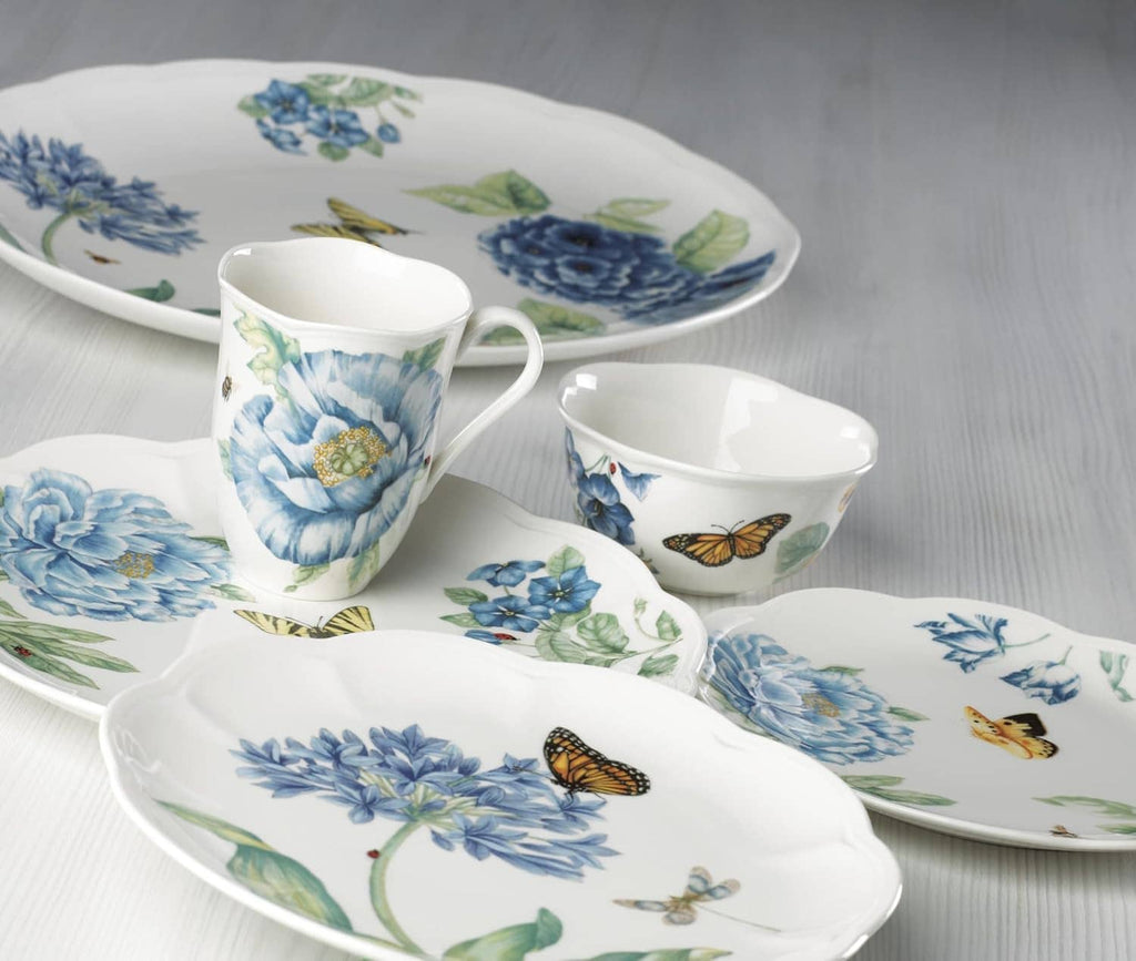 Blue floral dessert plates with butterflies on white, scalloped rims, shown with coordinating cup.
