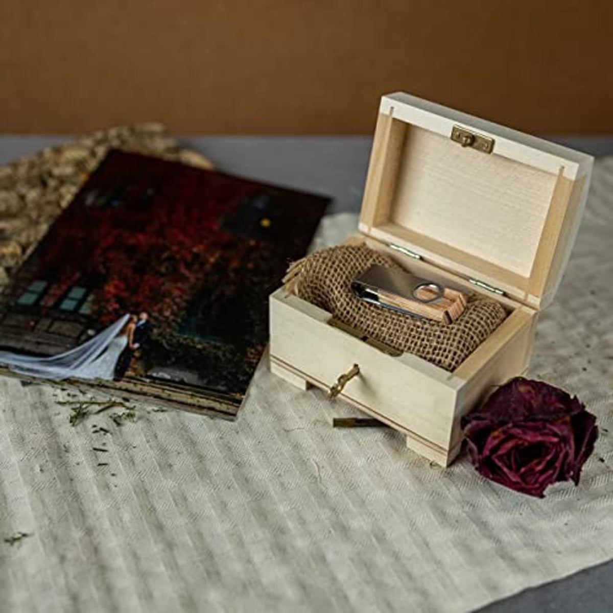 Small wooden jewelry box with lid open and ring accessory inside the drawer