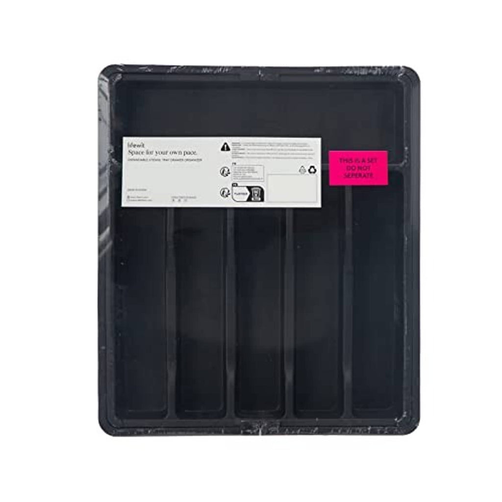 Dark utensil organizer tray underside with printed care label and compartment rows