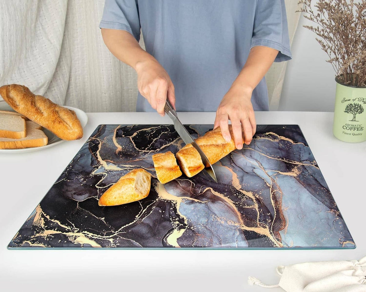 Tempered glass cutting board with blue and gold marbled finish, bread slices on top