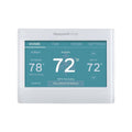 White smart color thermostat with teal touchscreen display showing indoor and set temperatures.