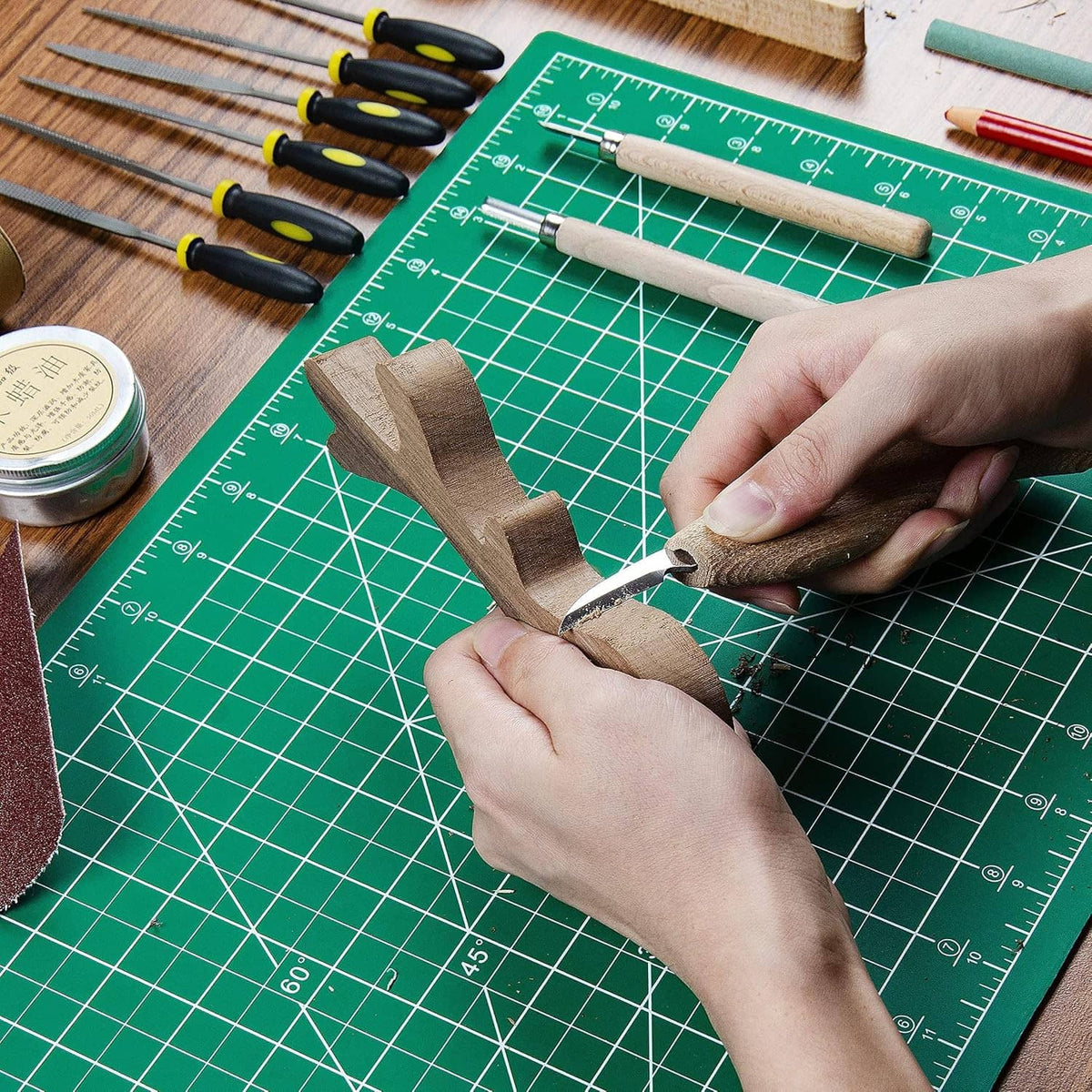Green cutting mat grid with hands trimming fabric with a craft tool