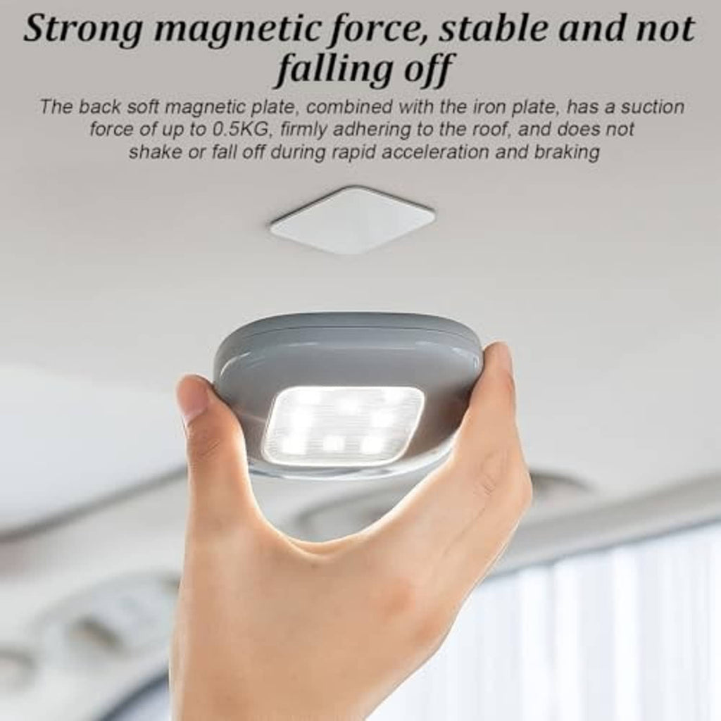 Gray magnetic LED car roof light held in hand, showing bright lens