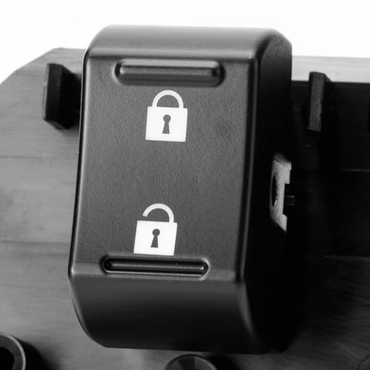 Close-up of power window switch buttons with lock symbols on dark gray/black housing.