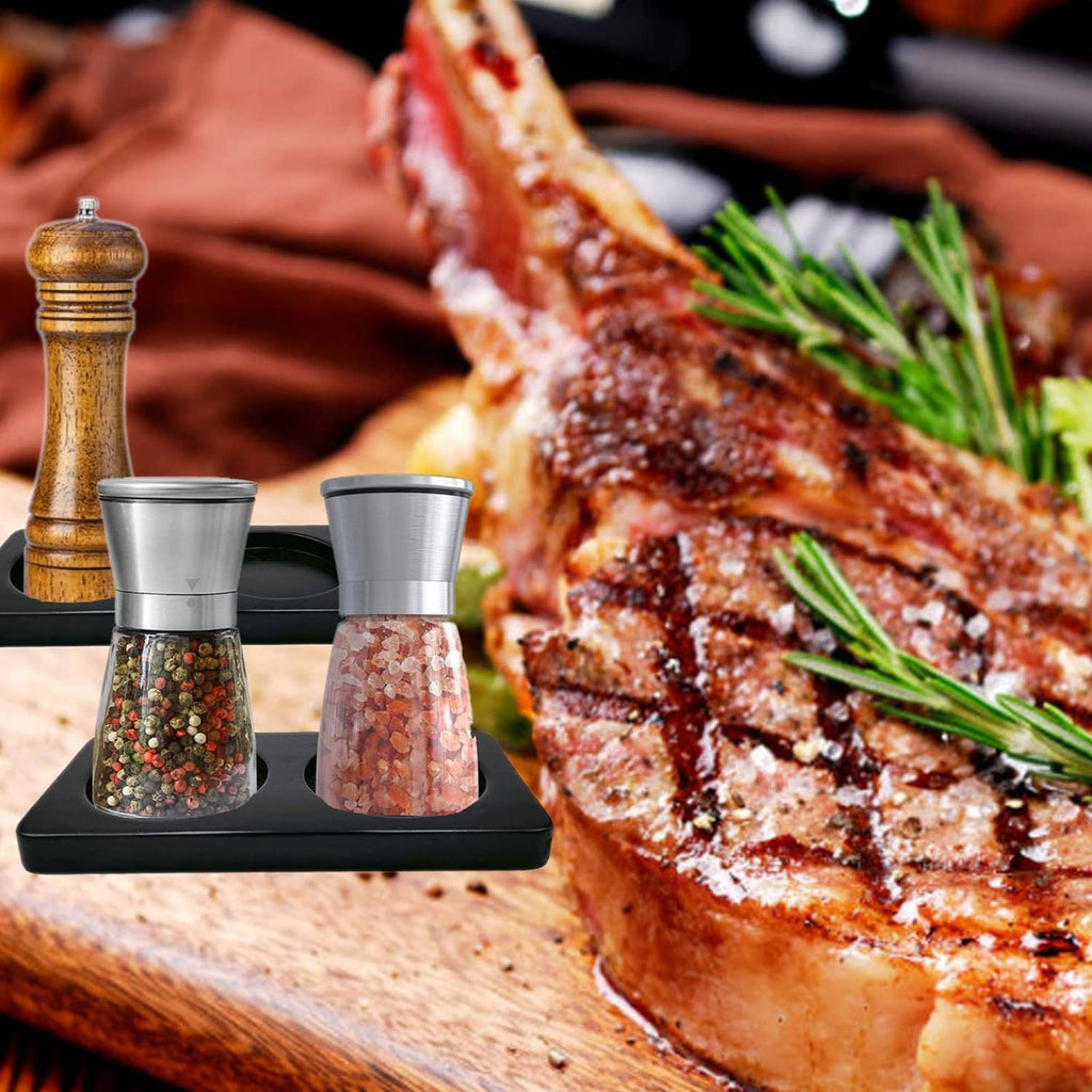 Black two-slot salt and pepper mill tray beside countertop seasoning mills