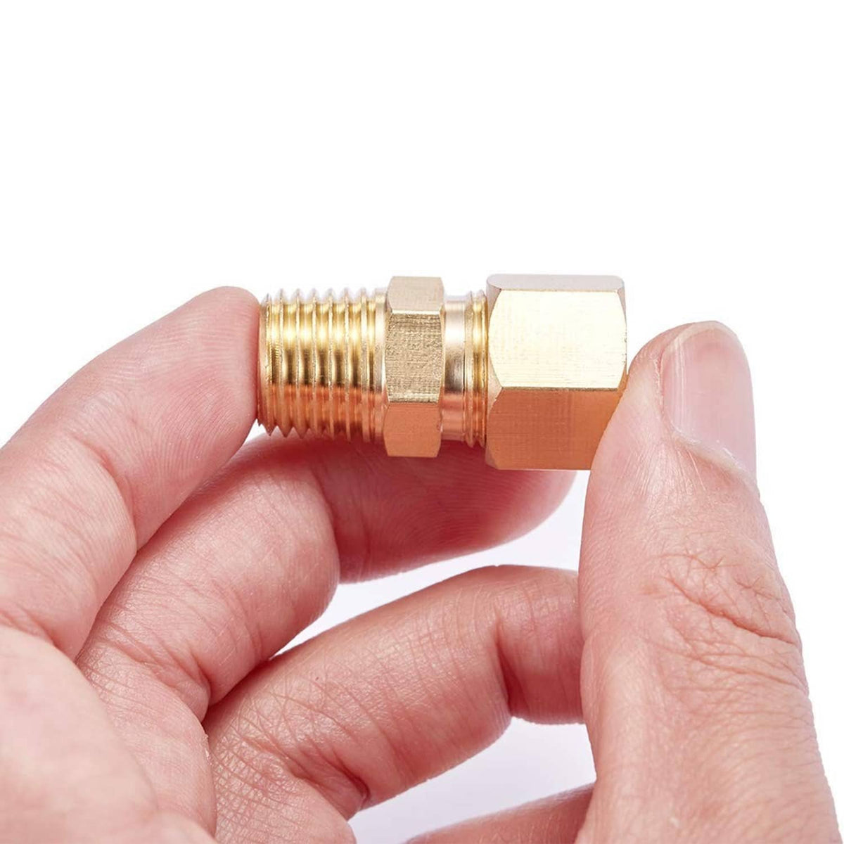 Brass 1/4" compression tube fitting held in hands; hex nut and male NPT threaded end