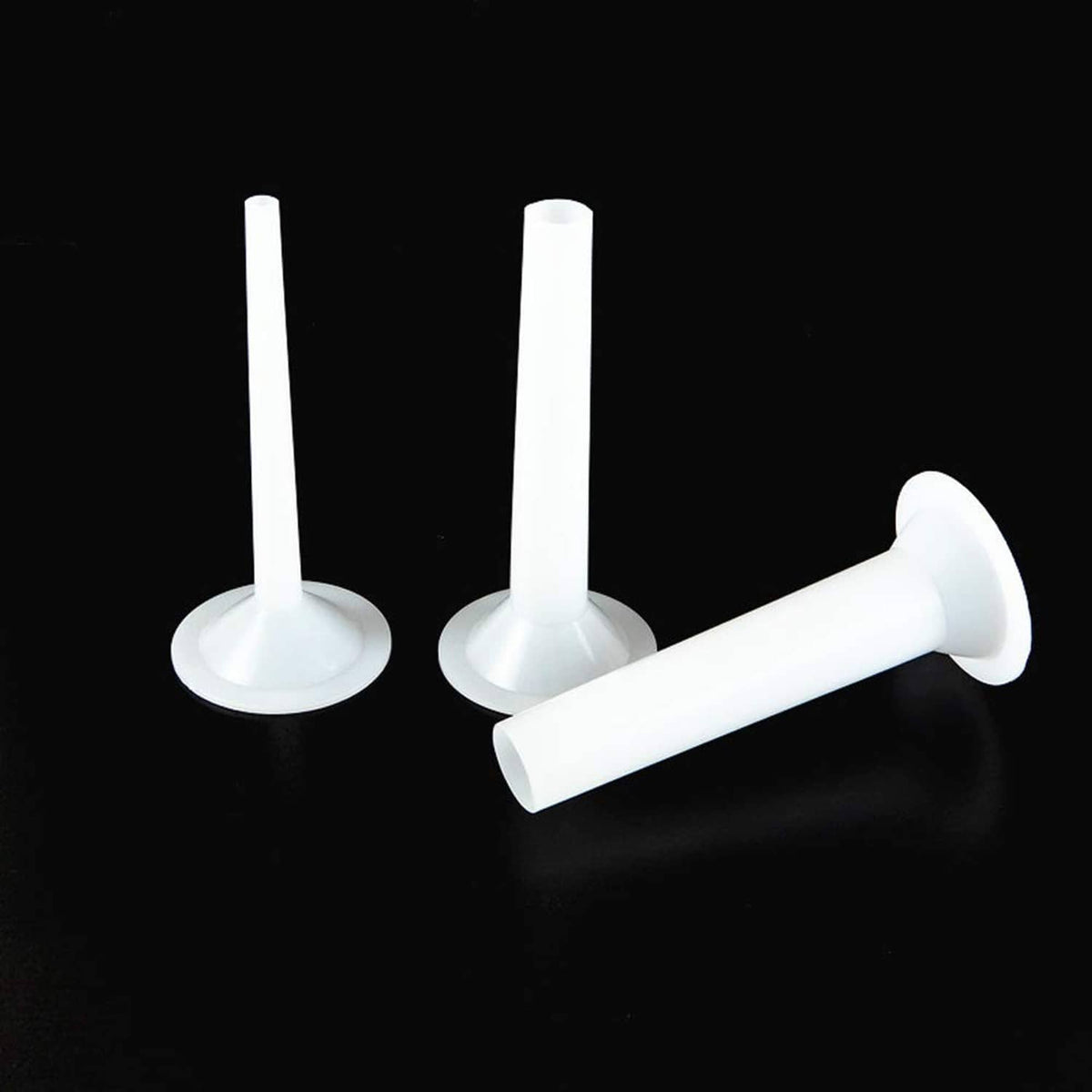 White plastic sausage stuffing tubes, two upright and one angled manual stuffer pieces