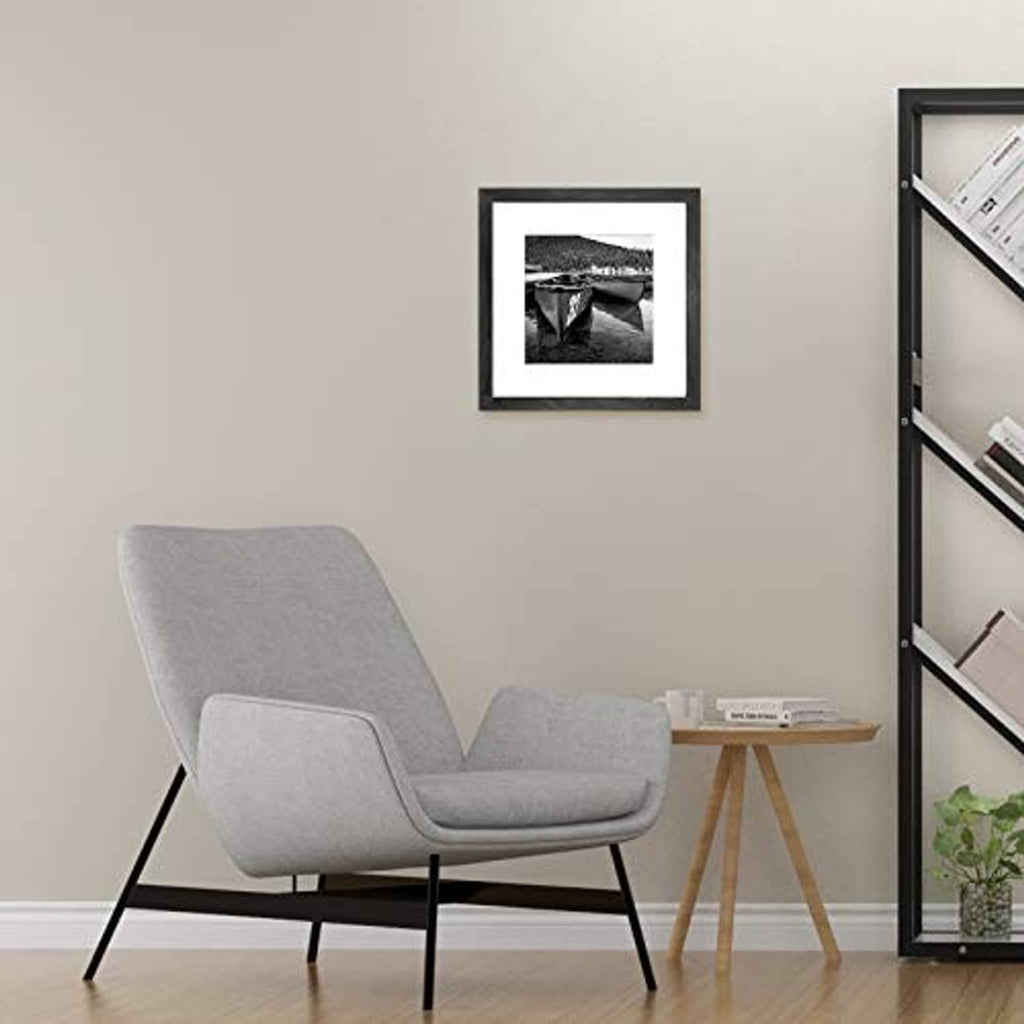 Black picture frame with white mat displaying a small black-and-white photo.