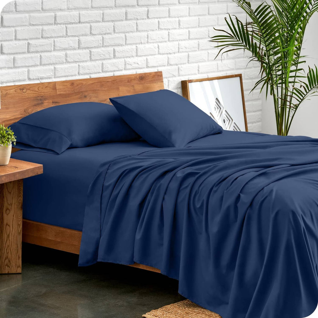 Dark blue full bed sheet set with fitted sheet and pillowcases, arranged on a bed
