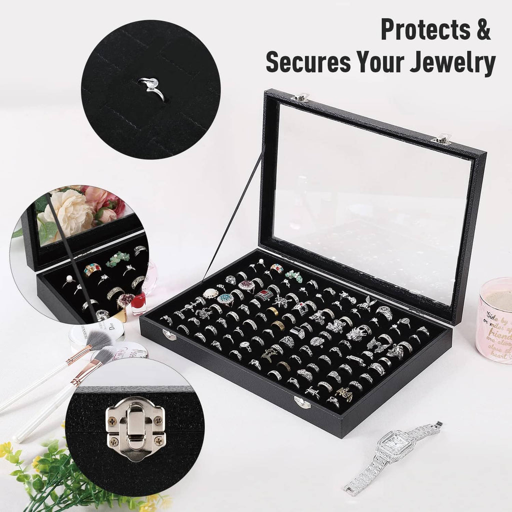 Black ring display case with clear cover open, showing many ring slots