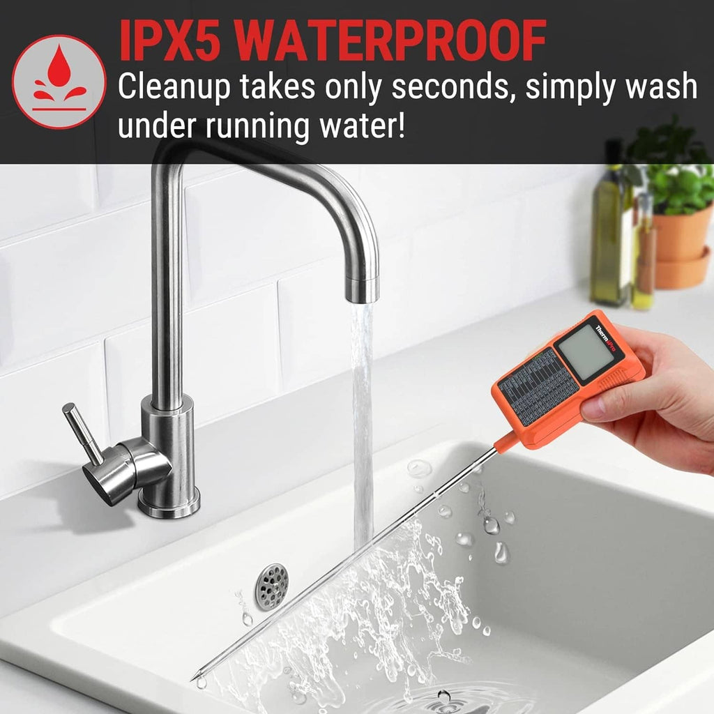 Orange waterproof digital thermometer with long probe held over a sink faucet