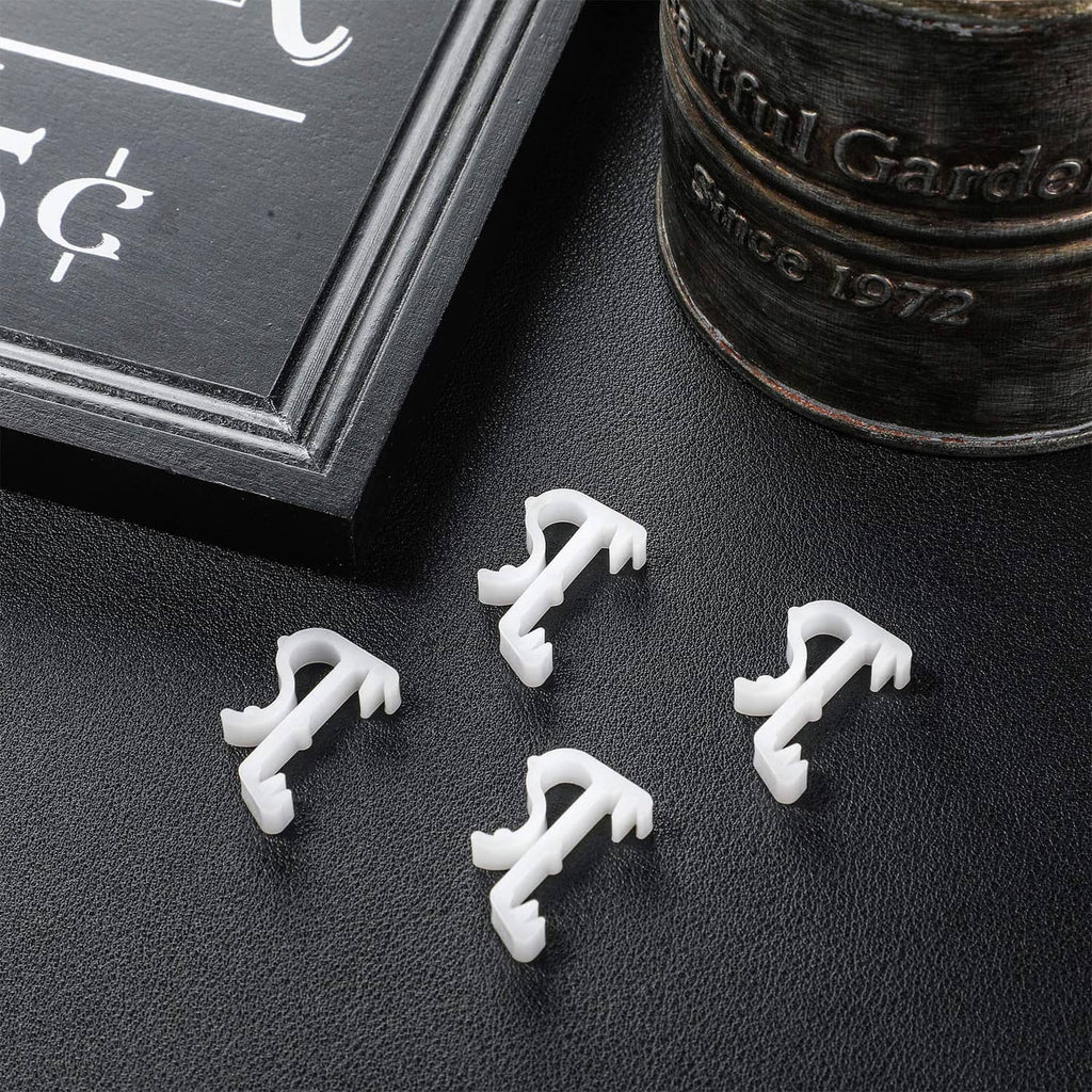 White blind valance clips laid out on a dark surface