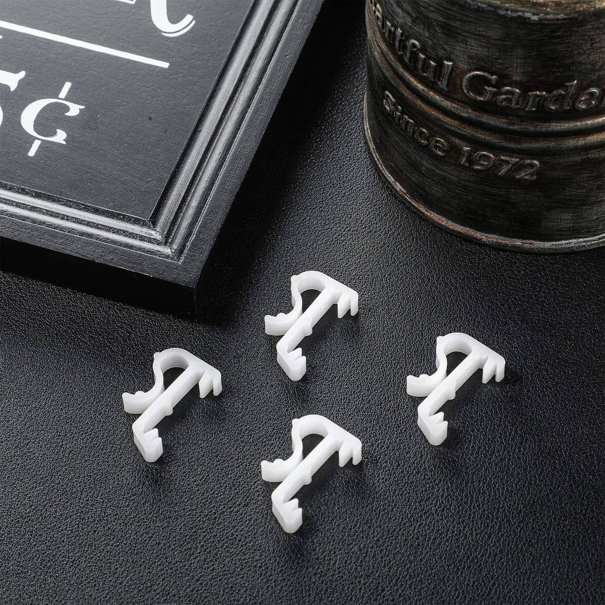 White blind valance clips laid out on a dark surface