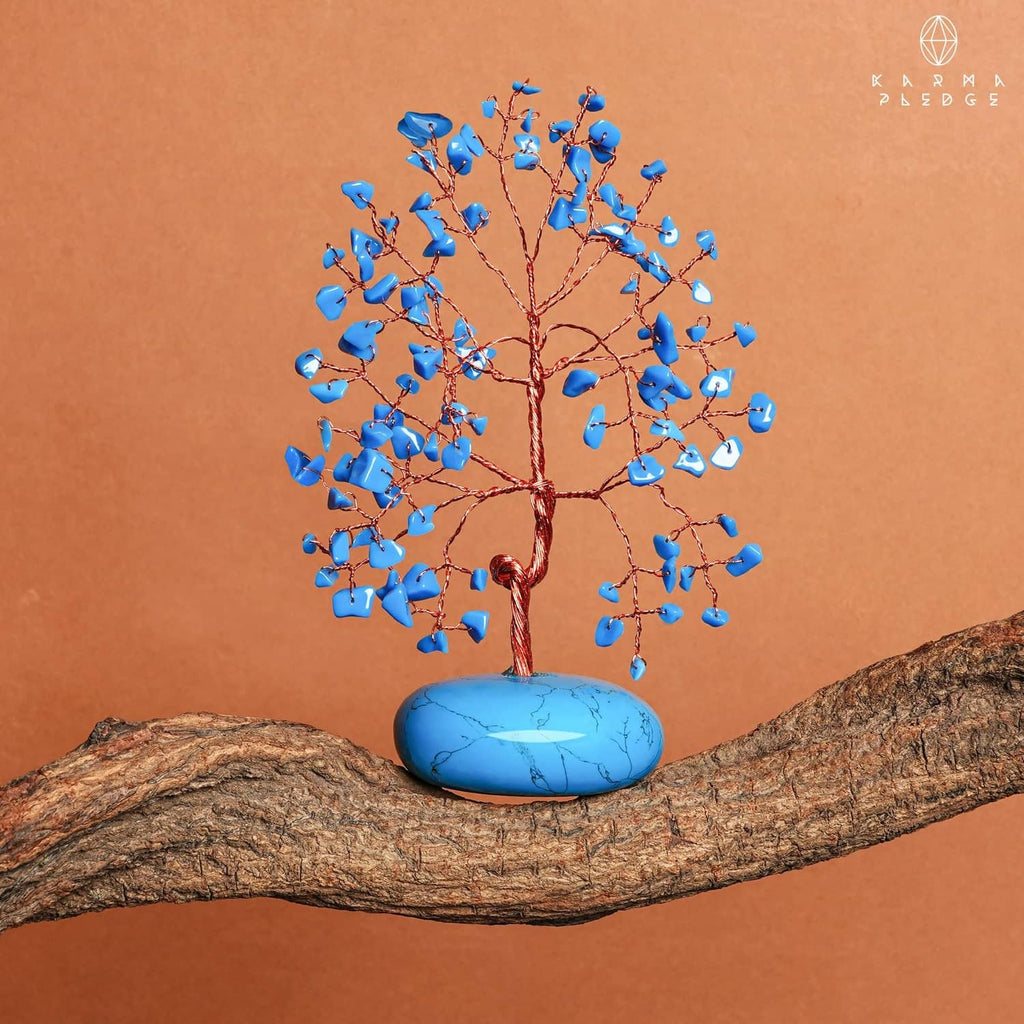 Turquoise crystal tree ornament with blue stone base on wooden log, blue crystal chips