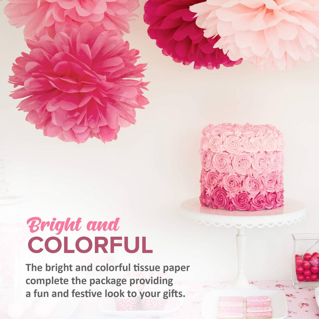 Pink and red tissue paper pom-poms and a decorated cake for bright celebrations