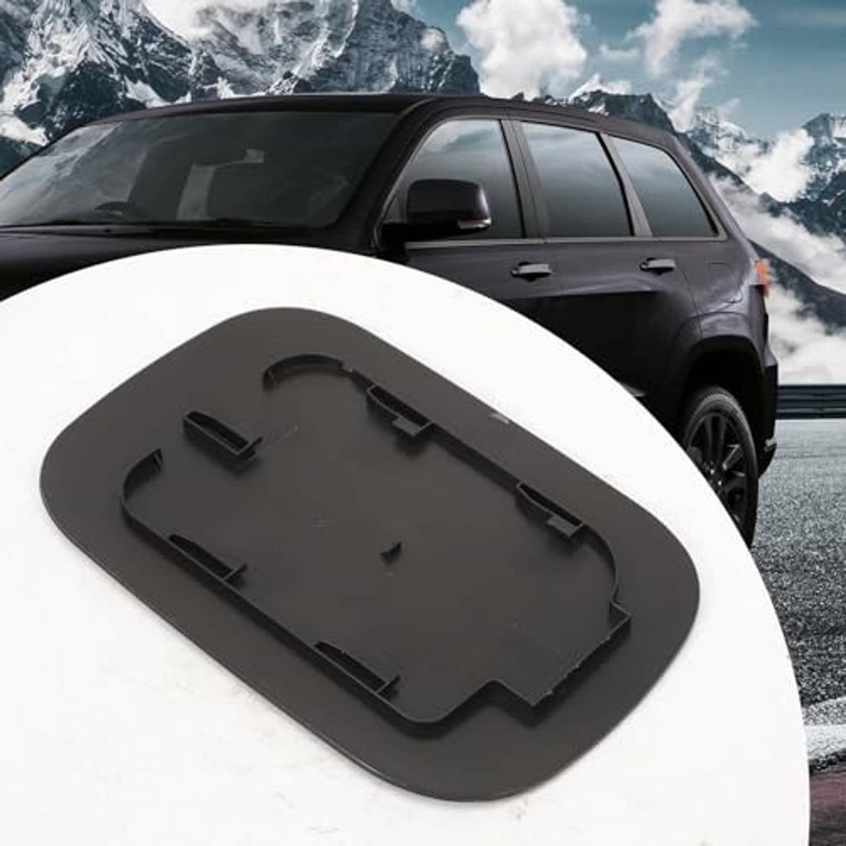 Black fuel tank filler door cover with mounting base plate, close-up