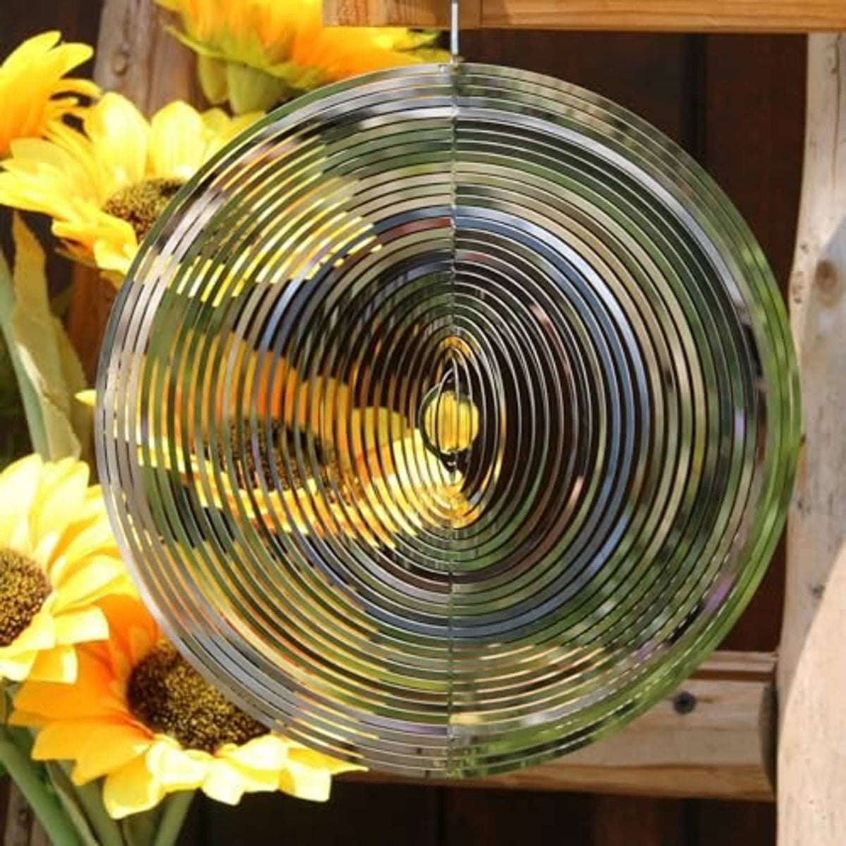 Silver round wind spinner with concentric metal rings and oval center charm