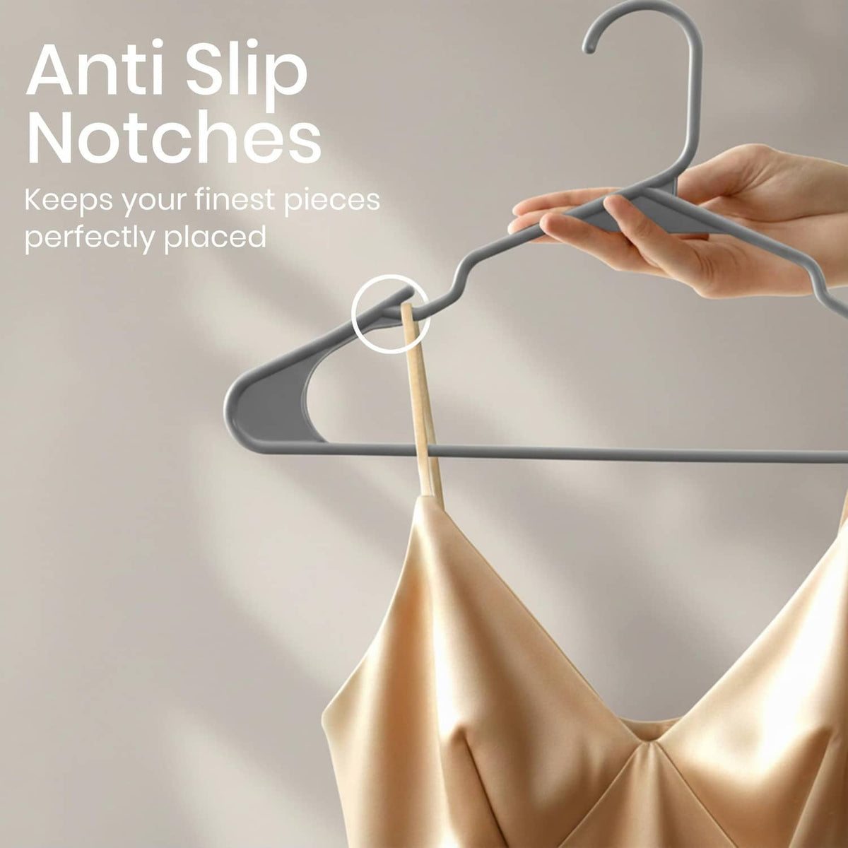 Gray plastic hanger with anti-slip notches, holding a beige dress garment