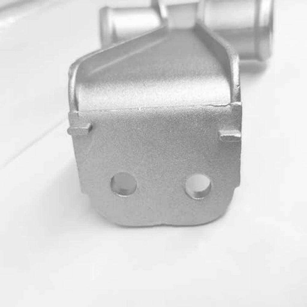 Close-up of silver metal coolant pipe bracket with two mounting screw holes
