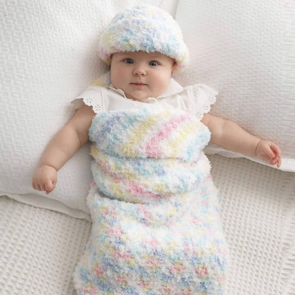 Baby in pastel fuzzy knit hat and matching outfit with rolled cuffs and hood