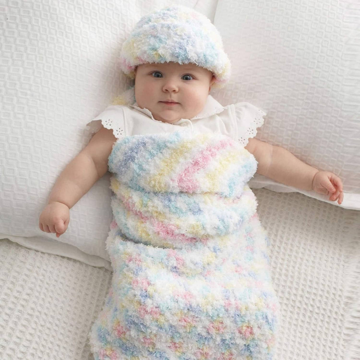 Baby in pastel fuzzy knit hat and matching outfit with rolled cuffs and hood