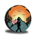 Orange RV spare tire cover with sunset mountains and hiker holding US flag