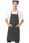 Unisex black chef apron with vertical white chalk stripes, neck strap and waist tie