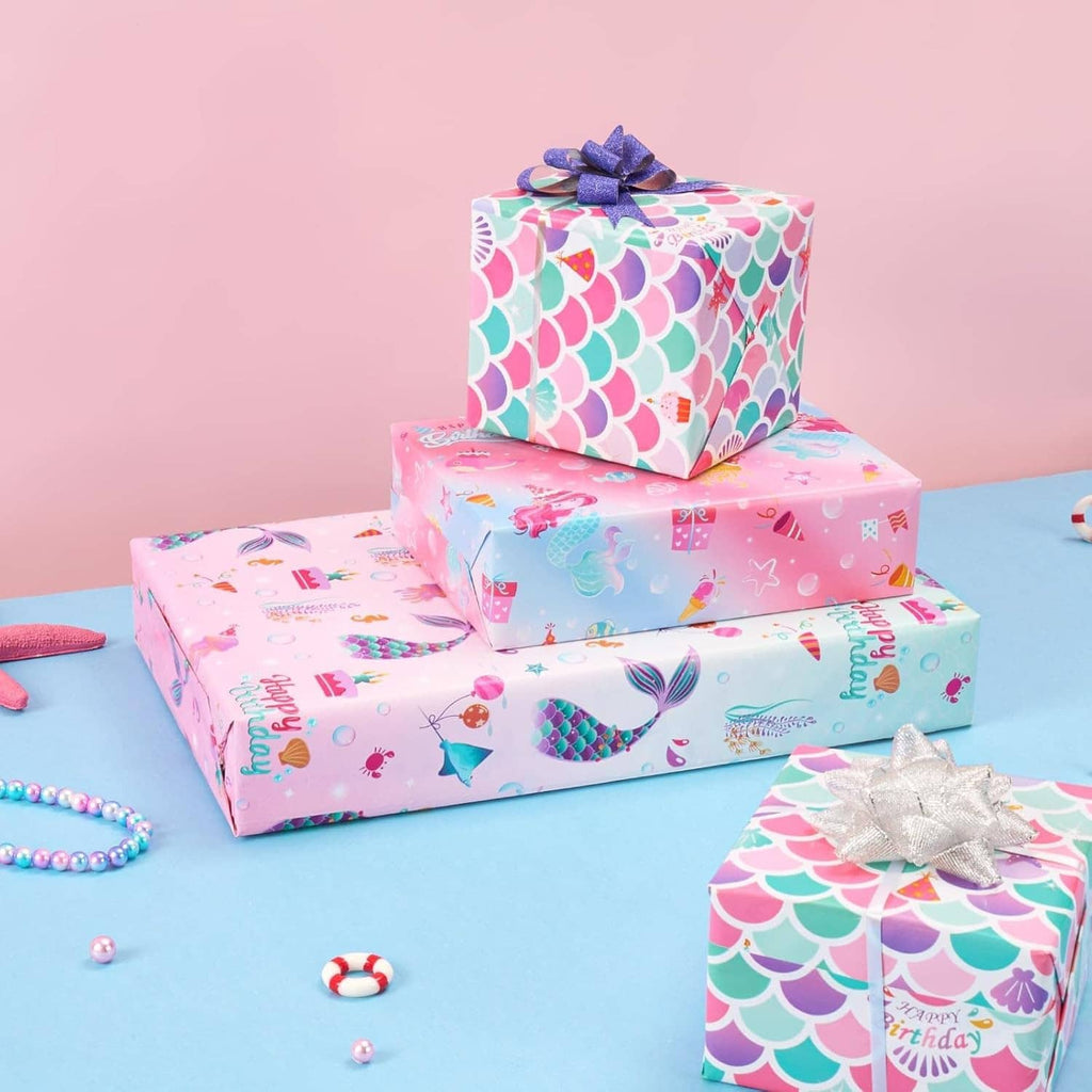 Birthday gifts wrapped with mermaid scale and ocean-themed pink wrapping paper