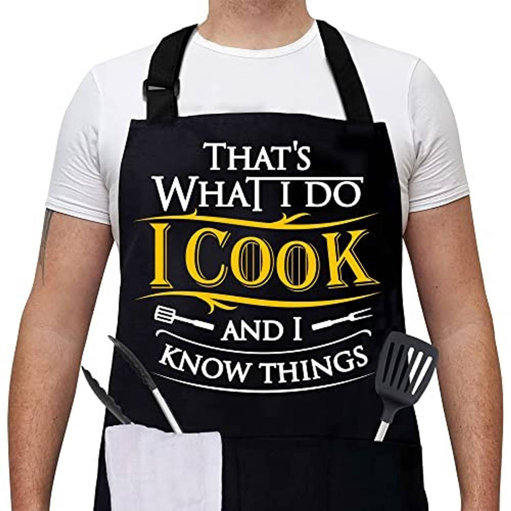 Black chef apron with cross-back straps and 'I Cook and I know things' chest print
