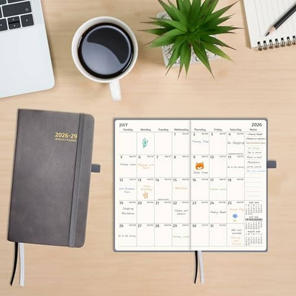 Gray 3-year pocket planner lying on desk with monthly calendar page open